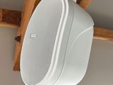 an image of a white speaker hanging from a wooden beam