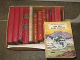 a box of books sitting on a table next to a pile of books