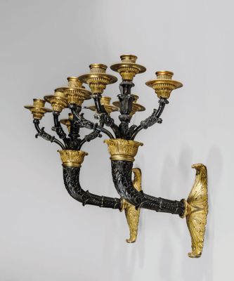 une image représentant un lustre doré et noir orné d'oiseaux