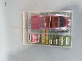 a red toy car in a plastic package on a table