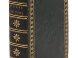 un livre noir et doré posé sur une surface blanche