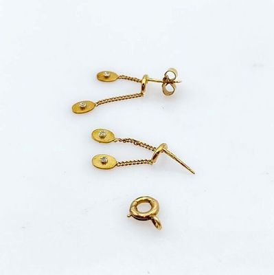 trois paires de boucles d'oreilles plaquées or sur un fond blanc