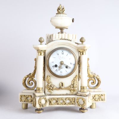 une horloge blanche et or posée sur une table