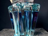 a blue bottle of perfume sitting on a table
