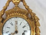 a gold clock that is sitting on a white surface