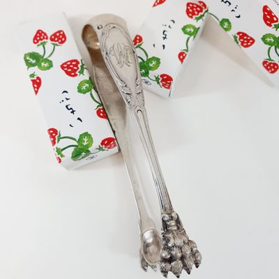 a silver spoon and a box of strawberries on a table