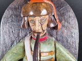 a wooden statue of a man with a pipe in his mouth