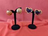 deux paires de boucles d'oreilles en forme de coeur sur des supports noirs sur fond rose