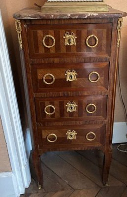 a wooden chest of drawers with a clock on top of it