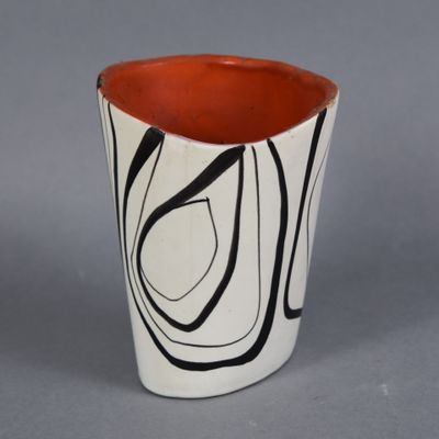 a black and white vase with a red rim