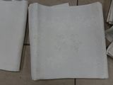 several napkins are laid out on a tiled floor with a monogram on them
