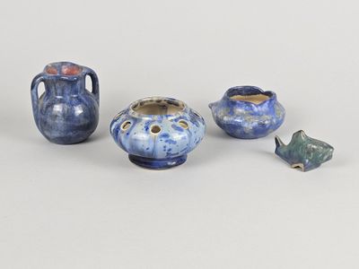 three small vases and a small figurine sitting on a table