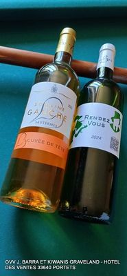 deux bouteilles de vin posées sur une table, à côté de baguettes