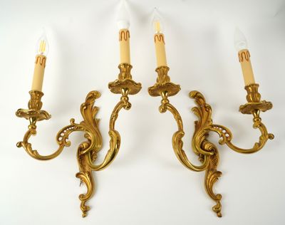 two gold wall sconces with candles on a white background