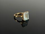 Gros plan sur une bague en or ornée d'une topaze bleue