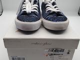 des baskets bleues et blanches pailletées posées sur une boîte