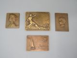 quatre plaques en bronze représentant un homme et une femme sur un fond blanc