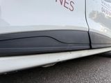a close up of a white car with a red sign on the side of it