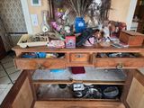 a wooden cabinet with many items on top of it