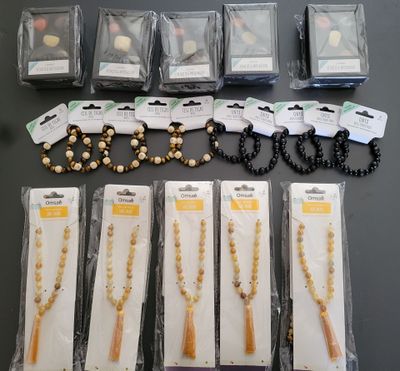 un lot de colliers et de bracelets composés de perles assorties, conditionnés dans des sachets en plastique