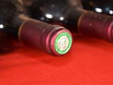 several bottles of wine are lined up on a red table