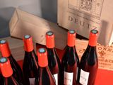 several bottles of red wine sitting on a table next to a wooden box