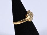 a close up of a gold ring with diamonds on a black ring stand