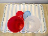 a red bowl and a blue bowl on a placemat