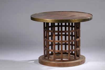 La table est en bois et possède un plateau rond.