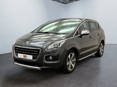 La voiture grise est garée dans une grande pièce au sol noir.