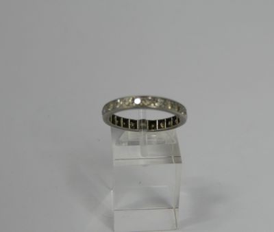 a close up of a ring on a clear stand on a white surface
