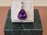 un gros plan d'un pendentif serti d'une pierre violette