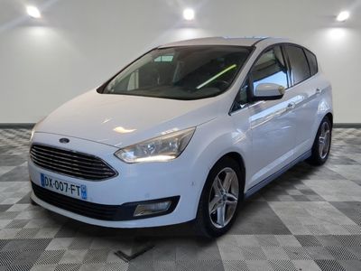 le ford c - max blanc est garé sur un sol en damier