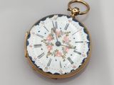 une petite montre de poche en or ornée d'un motif floral