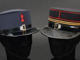pair of military hats on a mannequin head on a black background