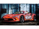 red sports car with graffiti on it parked in front of a building