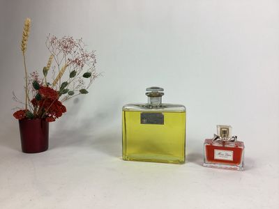 un flacon de parfum à côté d'un vase de fleurs