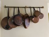 de nombreuses casseroles et poêles accrochées au mur