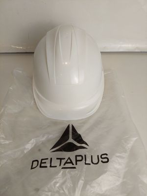 un casque de chantier blanc posé sur un sac en plastique