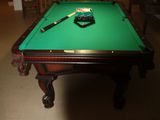 a pool table with a green cloth on it in a room