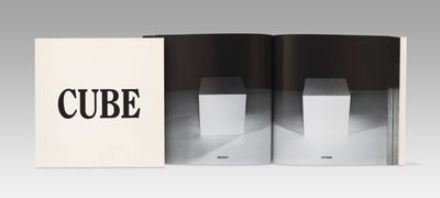 an open book with a black and white image of a cube