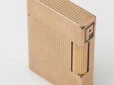 a gold lighter sitting on top of a white surface
