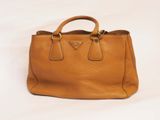 a brown leather handbag on a white background