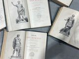 several old books sitting on top of a table next to each other