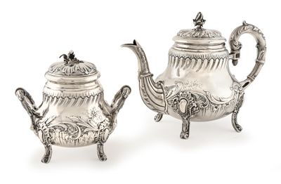paire de théières anciennes en argent sur un support, sur fond blanc