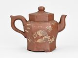 a brown tea pot with a design on it