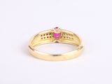 a close up of a gold ring with a ruby stone