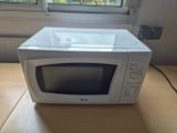 un micro-ondes blanc posé sur une table devant une fenêtre