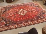 a rug on the floor in a room with a chair
