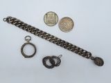 a close up of a chain bracelet, a coin, and a pair of earrings